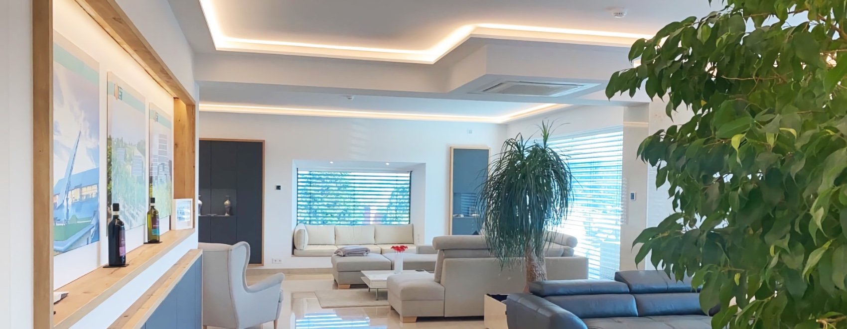 Luxuriös ausgestattetes Wohnzimmer mit LED-Vouten zur indirekten Beleuchtung. Warm-weiße Ausleuchtung.